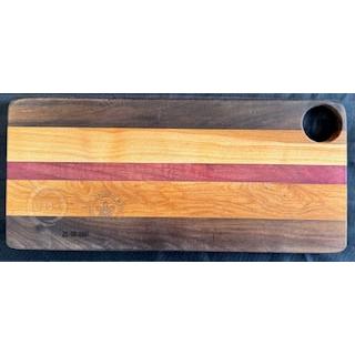A rectangular serving board with stripes of walnut and purple heart wood, featuring a hole at one end.