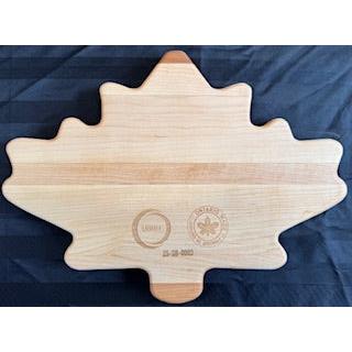 A maple leaf shaped serving board with the word 'Amherstburg' engraved on it.